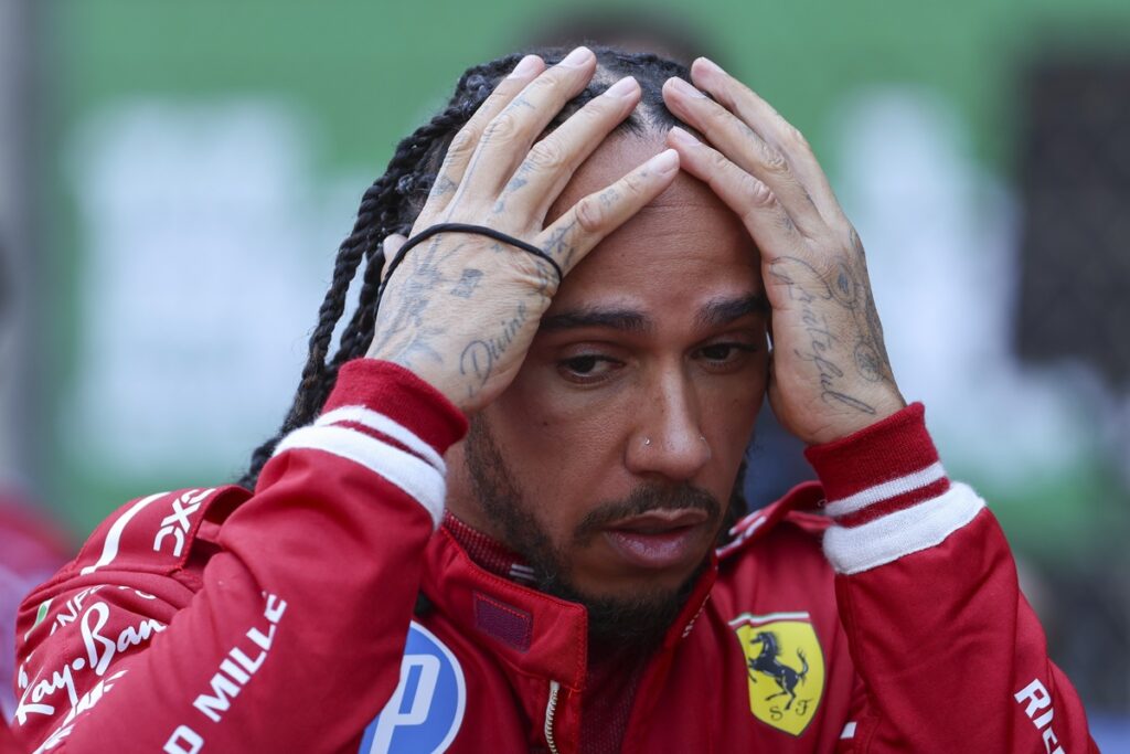 Lewis Hamilton v červené kombinéze Ferrari po závodě, S přemýšlivým pohledem bilancuje svou první sezónu u Scuderie.